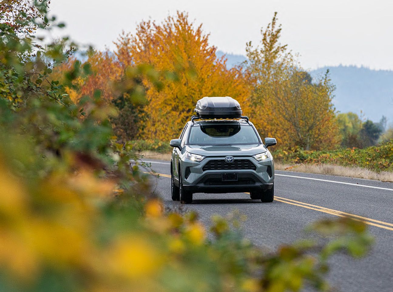 A cargo box on a car driving down the road